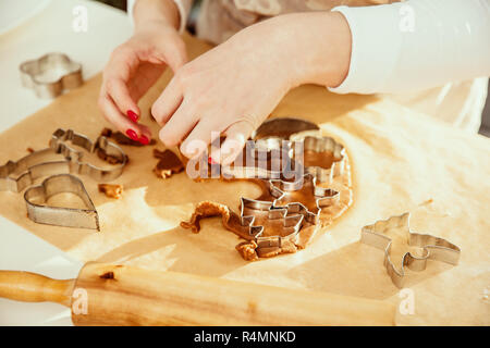 Donna di mano taglia pasta di Natale dal pan di zenzero. Foto Stock