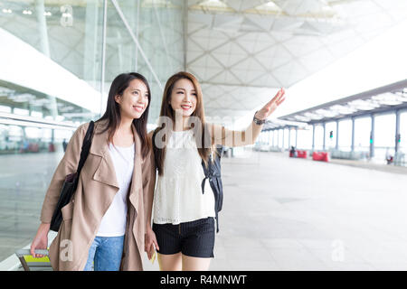 Gli amici che vogliono un taxi in aeroporto Foto Stock