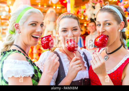 Gli amici di mangiare le mele di caramella al Oktoberfest Foto Stock