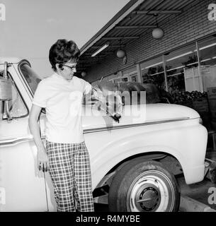 Una donna che tiene la testa di un cervo morto buck sul cofano del suo pickup truck, ca. 1967. Foto Stock