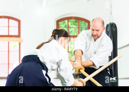 L uomo e la donna avente Aikido spada lotta Foto Stock