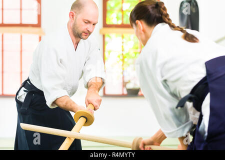 L uomo e la donna avente Aikido spada lotta Foto Stock