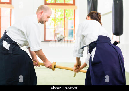 L uomo e la donna avente Aikido spada lotta Foto Stock