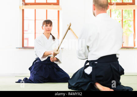 L uomo e la donna avente Aikido spada lotta Foto Stock