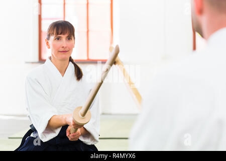 L uomo e la donna avente Aikido spada lotta Foto Stock