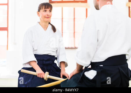 L uomo e la donna avente Aikido spada lotta Foto Stock