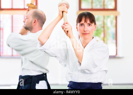 L uomo e la donna avente Aikido spada lotta Foto Stock