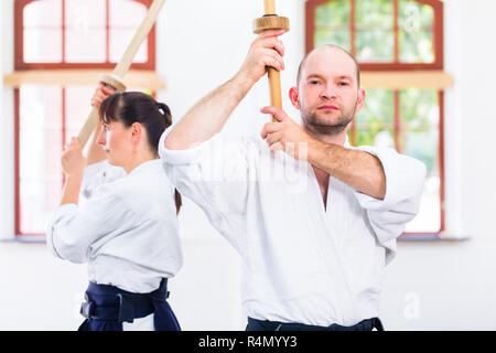 L uomo e la donna avente Aikido spada lotta Foto Stock