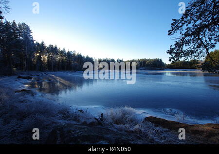 Un lago ghiacciato in Dalarna in una fredda giornata invernale Foto Stock