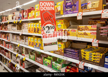 Supermercato Coles in Australia, biscotti e spuntini esposti in vendita con un grande cartello rosso a prezzi più bassi Foto Stock
