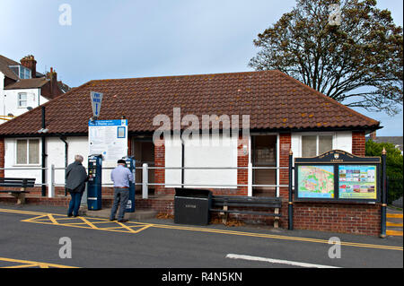 Due persone che ottengono i biglietti per il parcheggio presso un'auto pubblica par a Cromer, Norfolk, UK Foto Stock