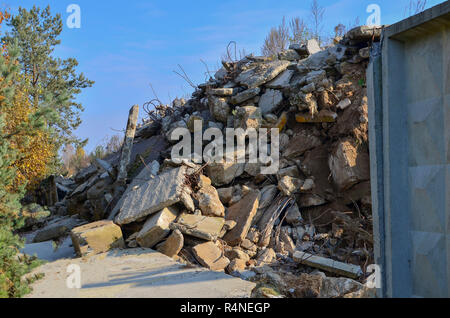 Rifiuti di costruzione, in cemento armato e blocchi di raccordi arrugginito. Demolito edificio con filo cemento armato nel fuoco Foto Stock