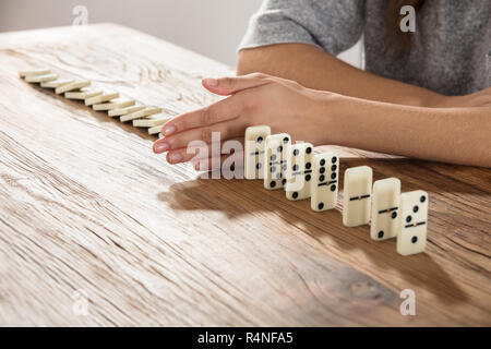 Imprenditrice supporta Domino cada Foto Stock