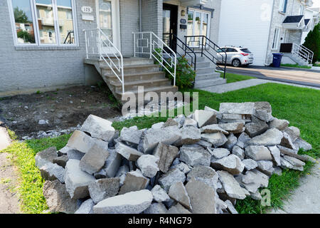 Pila di detriti di cemento a sinistra dopo la demolizione di un vicolo che conduce all'ingresso anteriore di una casa suburbana. Foto Stock