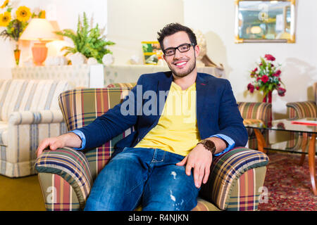 Uomo poltrona di acquisto nel negozio di mobili Foto Stock