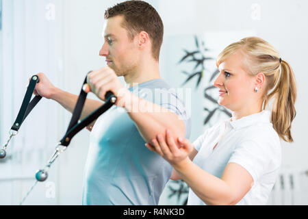 Fisioterapista excercising paziente in pratica Foto Stock