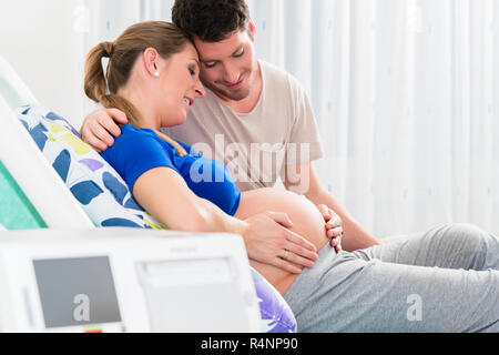 Donna incinta in sala parto con il suo uomo Foto Stock