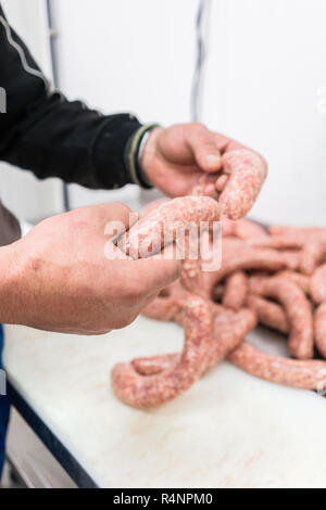 Butcher preparare le salsicce in fabbrica a base di carne Foto Stock