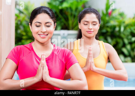 Due donne nella posizione del loto durante la pratica dello yoga Foto Stock