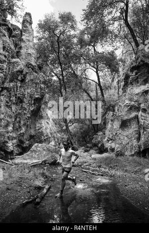 Un uomo che attraversa un ruscello mentre lungo un sentiero a El Arquito in Huasca de Ocampo, hidalgo, Messico. Foto Stock