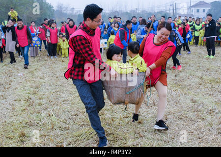 Changxing cinese della provincia dello Zhejiang. 28 Nov, 2018. I genitori e i bambini che frequentano un campo di riso attività ricreative nelle Changxing, est della Cina di Provincia dello Zhejiang, nov. 28, 2018. La manifestazione è stata organizzata da un Asilo locale il mercoledì per aumentare la consapevolezza del fitness e incoraggiare genitori-figli interazione. Credito: Xu Yu/Xinhua/Alamy Live News Foto Stock