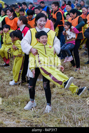 Changxing cinese della provincia dello Zhejiang. 28 Nov, 2018. I genitori e i bambini che frequentano un campo di riso attività ricreative nelle Changxing, est della Cina di Provincia dello Zhejiang, nov. 28, 2018. La manifestazione è stata organizzata da un Asilo locale il mercoledì per aumentare la consapevolezza del fitness e incoraggiare genitori-figli interazione. Credito: Xu Yu/Xinhua/Alamy Live News Foto Stock