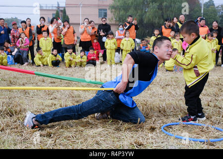 Changxing cinese della provincia dello Zhejiang. 28 Nov, 2018. Un uomo e un ragazzo di partecipare ad un campo di riso attività ricreative nelle Changxing, est della Cina di Provincia dello Zhejiang, nov. 28, 2018. La manifestazione è stata organizzata da un Asilo locale il mercoledì per aumentare la consapevolezza del fitness e incoraggiare genitori-figli interazione. Credito: Xu Yu/Xinhua/Alamy Live News Foto Stock