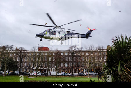 Worthing Sussex, Regno Unito. 28 Novembre 2018 - Il Kent Surrey & Sussex Air Ambulance decolla da Steyne Gardens in Worthing dopo la risposta a una relazione di un uomo caduto da un parcheggio in Worthing . Forze di polizia sono stati avvisati al centro Guildbourne parcheggio auto da South East Coast ambulanza circa 2,08 pm Mercoledì (28 novembre). Credito: Simon Dack/Alamy Live News Foto Stock