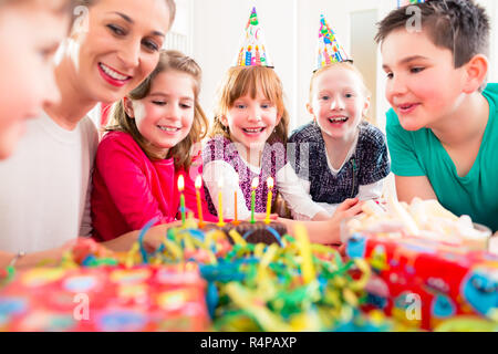 Bambino sulla festa di compleanno soffiando candele sulla torta Foto Stock