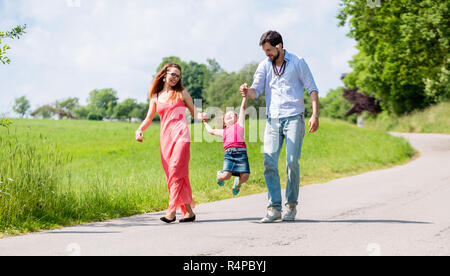 Famiglia lasciando kid volare in estate a piedi Foto Stock