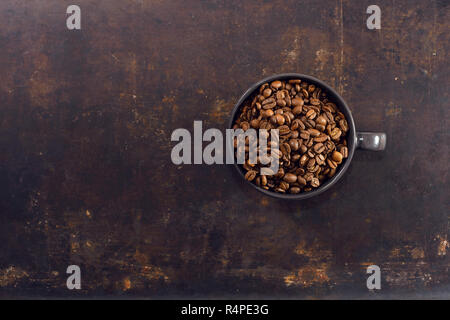 I chicchi di caffè in tazza di caffè sullo sfondo Foto Stock