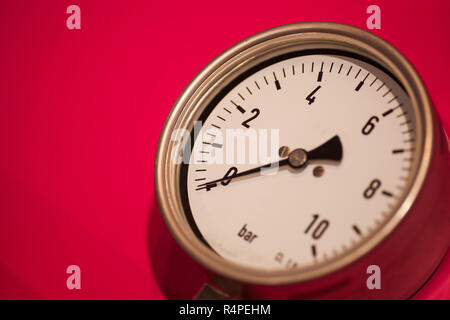 Manometro su sfondo rosso Foto Stock