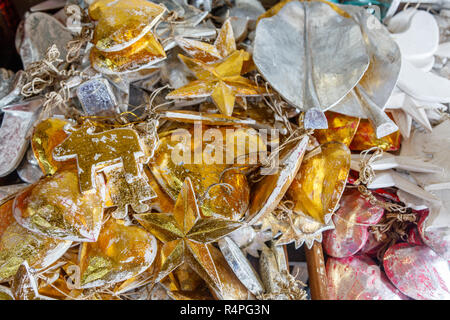 Legno decorazione di Natale - ghirlande di argento e di stelle dorate e lascia in un negozio di souvenir a Bali, in Indonesia Foto Stock