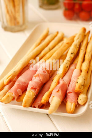 Pane italiano bastoni grissini con carne di maiale e prosciutto Foto Stock