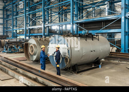 Lavoratore con esperienza di controllare la qualità del prodotto caldaie Foto Stock