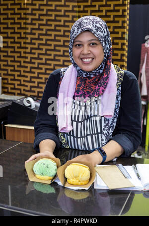 Giovane cameriera malese presentando gelato dessert Puff, Ipoh, Malaysia. Foto Stock