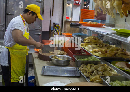 Cucina lavoratore Pollo di taglio in Lou Wong ristorante, famoso per il pollo, riso e germogli di soia (Tauge Ayam), un Ipoh specialità. Ipoh, Malaysia. Foto Stock