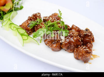 Saltata di costolette di maiale con seasame e erbe sul piatto bianco Foto Stock