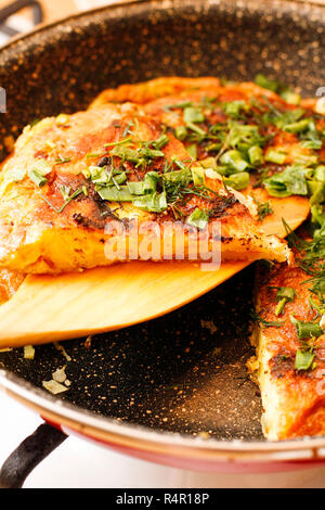 Noiosa spagnolo tortilla di patate con erbe in padella nera Foto Stock