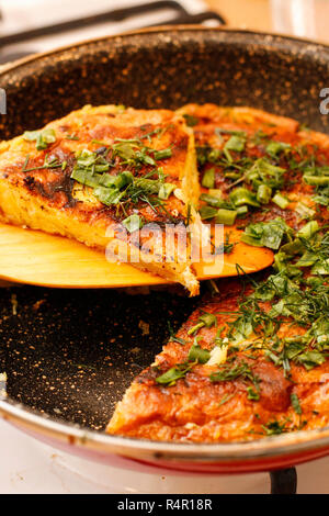 Noiosa spagnolo tortilla di patate con erbe in padella nera Foto Stock