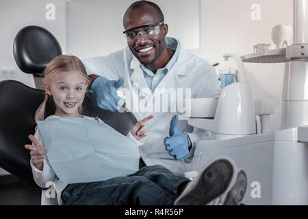 Bello di carnagione scura uomo seduto vicino al suo paziente Foto Stock