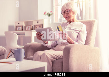 Radiant a pelo corto lady stare nella stanza vivente Foto Stock