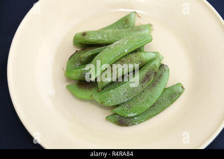 Fritti di piselli verdi sul piatto bianco Foto Stock