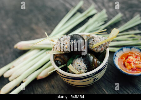 Vietnamita al vapore di lumache farcite con carne di maiale e la citronella, la salsa di pesce sul tavolo di legno Foto Stock