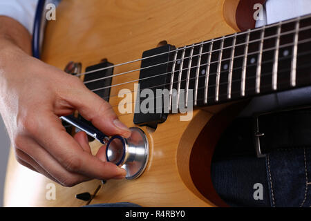 Bracci maschio tenere testa stetoscopio la diagnosi di chitarra Foto Stock