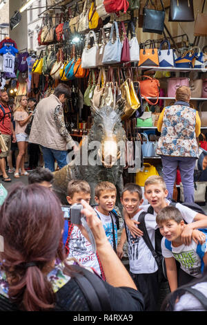 Il Porcellino statua nel Mercato Nuovo, circondato da giovani turisti in Firenze, Italia. Foto Stock