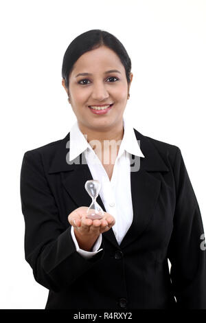 Business donna tenendo premuto contro la clessidra white Foto Stock