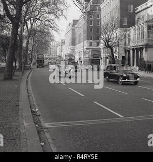 Anni sessanta, storico, autobus Routemaster, auto e taxi andando verso Park Lane, verso Hyde Park Corner. La strada è un inner ring road da Hyde Park, in Westminster, Londra, Inghilterra, Regno Unito. Foto Stock