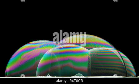 Iridescenze sulla superficie di alcune bolle di sapone illuminate dal basso Foto Stock