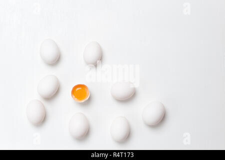 Uova fresche, incolume e uno di uova rotte con tuorlo giallo su sfondo bianco. Mangiare sano concetto . Foto Stock